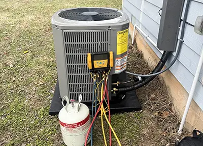 An HVAC tech performs diagnostic on an air conditioner.